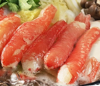 鍋の中で白菜やきのこと一緒に煮えているカニのむき身